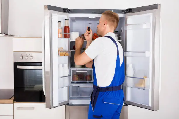 Technician repairing a refrigerator